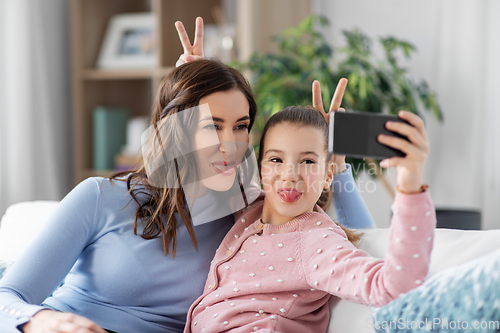 Image of happy family taking selfie by smartphone at home