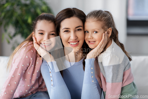 Image of happy smiling mother with two daughters at home