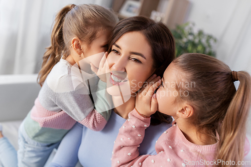 Image of happy mother and daughters gossiping at home