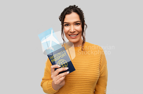 Image of happy woman with air ticket and immunity passport