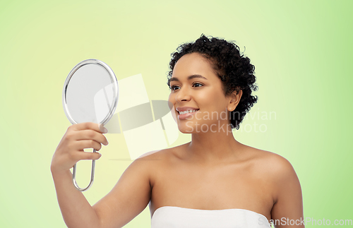 Image of smiling african american woman looking to mirror