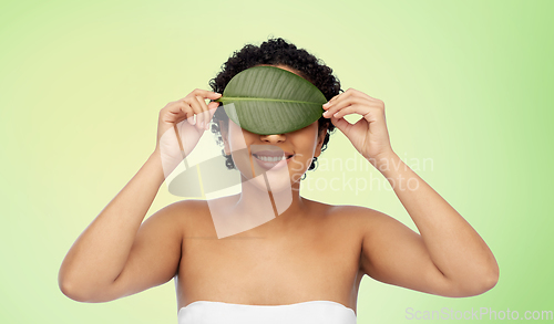 Image of portrait of african american woman with green leaf