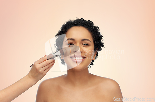 Image of happy woman and hand of make up artist with brush