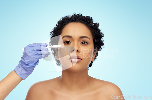 Image of african american woman and hand with scalpel knife