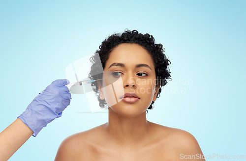 Image of face of african woman and hand with syringe