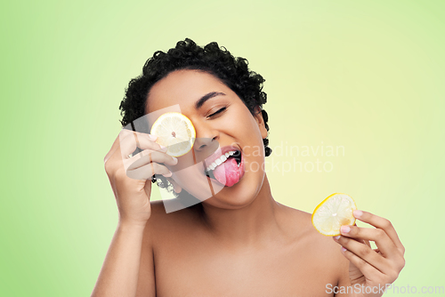 Image of african american woman making eye mask of lemons