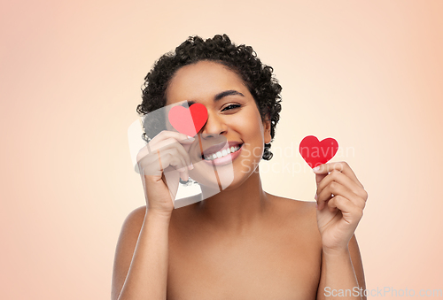 Image of african american woman covering eyes with hearts