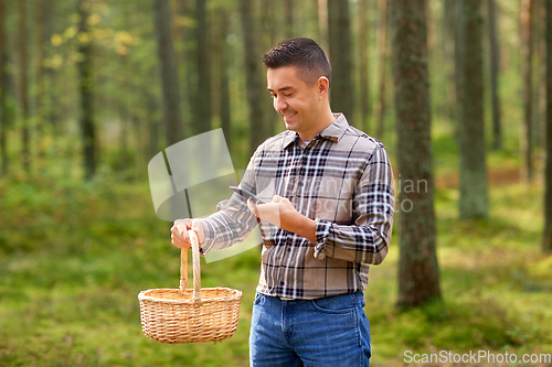 Image of man using smartphone to identify mushroom