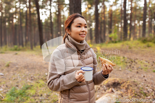 Image of woman with mushrooms drinks tea and eats in forest