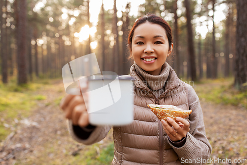 Image of woman with mushrooms drinks tea and eats in forest