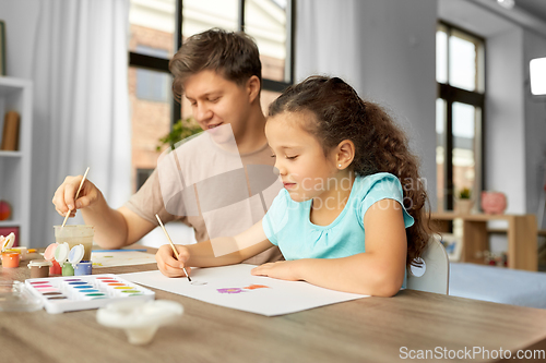 Image of happy father with little daughter drawing at home
