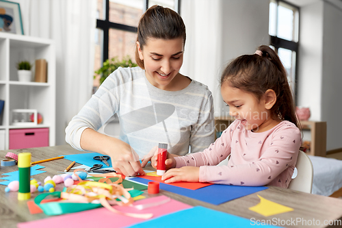 Image of daughter with mother making applique at home