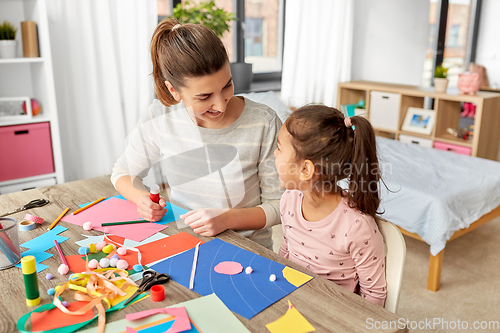 Image of daughter with mother making applique at home