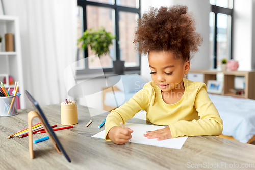 Image of little girl drawing with coloring pencils at home