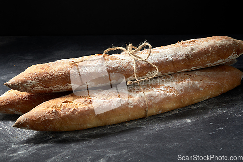 Image of pile of baguette bread loaves tied with rope