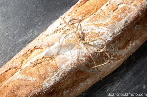 Image of pile of baguette bread loaves tied with rope