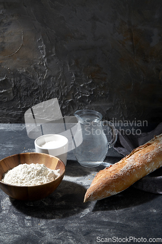 Image of bread, wheat flour, salt and water in glass jug