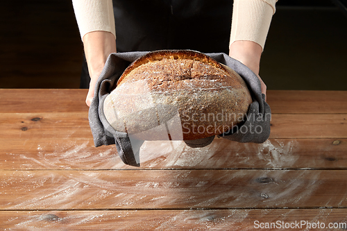 Image of female baker with homemade bread at bakery