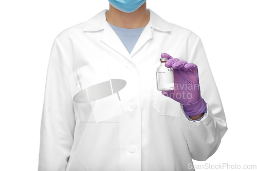 Image of close up of doctor in mask with medicine in bottle