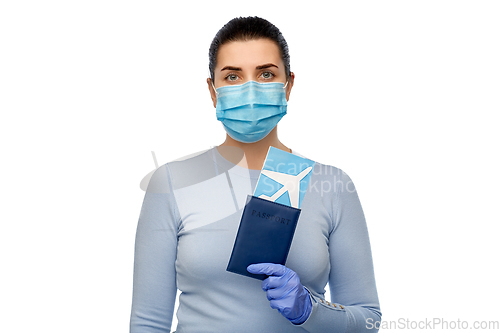 Image of young woman in mask with air ticket and passport