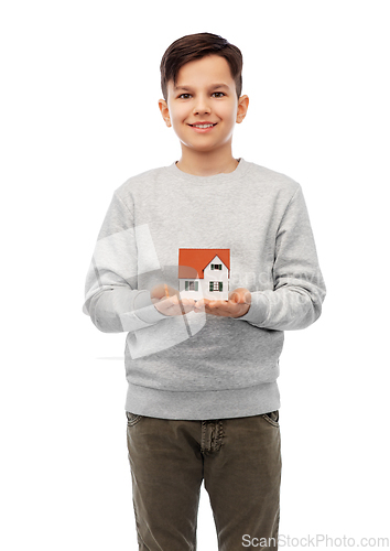 Image of smiling boy holding house model