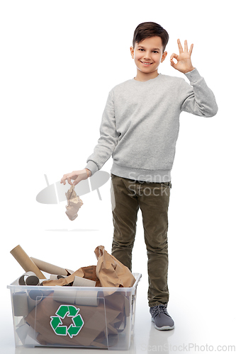 Image of smiling boy sorting paper waste showing ok sign