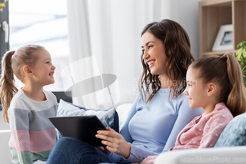 Image of happy mother and daughters with tablet pc at home