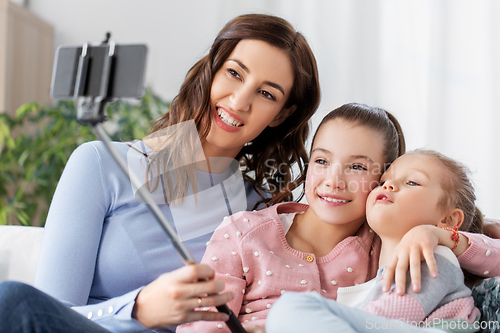 Image of happy family taking selfie by smartphone at home