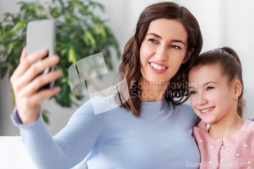 Image of happy family taking selfie by smartphone at home