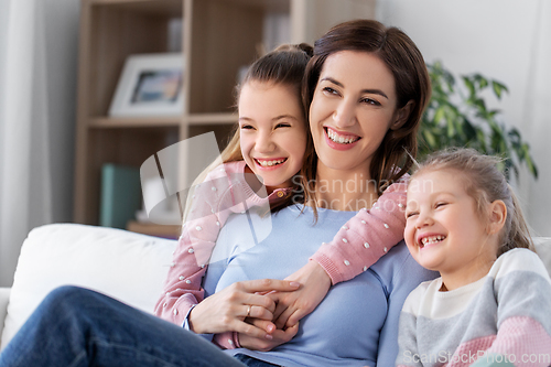 Image of happy smiling mother with two daughters at home