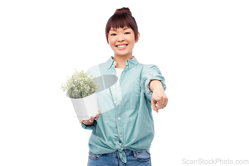 Image of happy smiling asian woman holding flower in pot