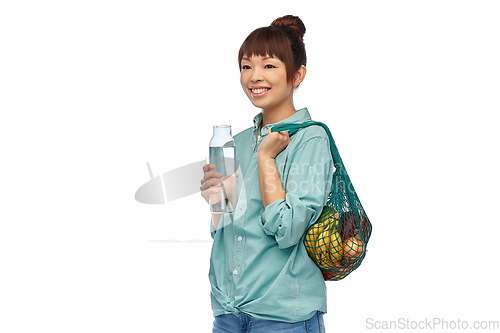 Image of woman with food in string bag and glass bottle