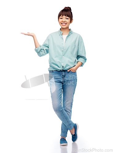 Image of happy asian woman holding something on her hand