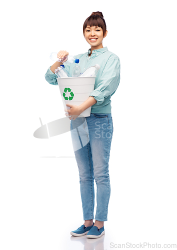 Image of smiling young woman sorting plastic waste