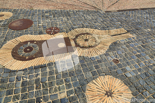Image of Unusual pavement with creative pattern from rusty metal details,