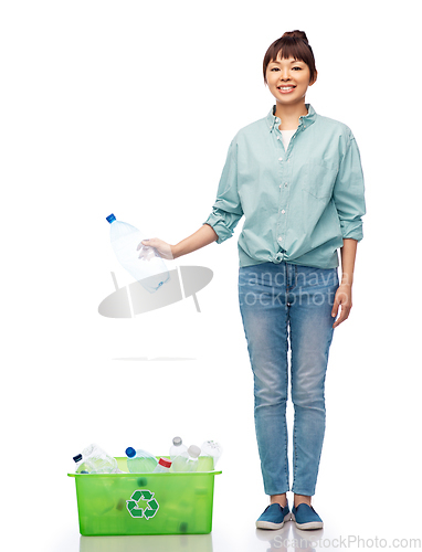 Image of smiling young asian woman sorting plastic waste