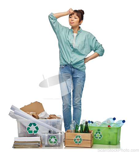 Image of tired woman sorting paper, metal and plastic waste