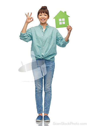 Image of asian woman with green house showing ok hand sign