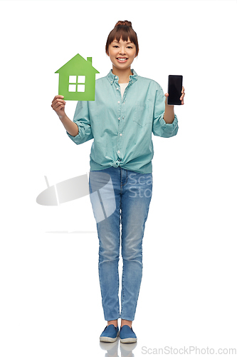 Image of smiling asian woman holding green house