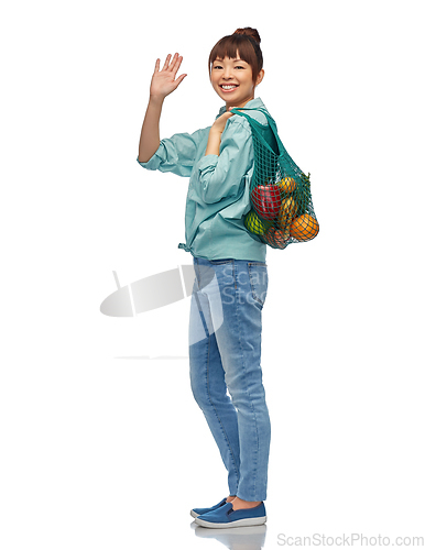 Image of happy asian woman with food in reusable string bag