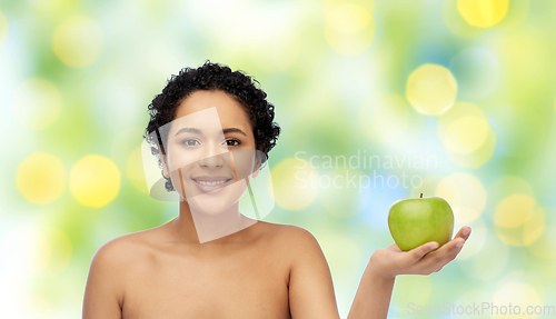 Image of happy african american woman holding green apple