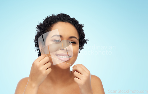 Image of african woman cleaning teeth with dental floss