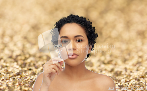 Image of african american woman with eyelash curler