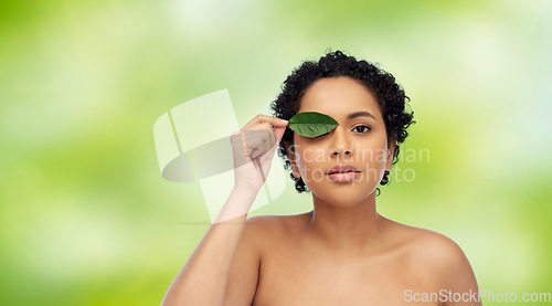 Image of portrait of african american woman with green leaf