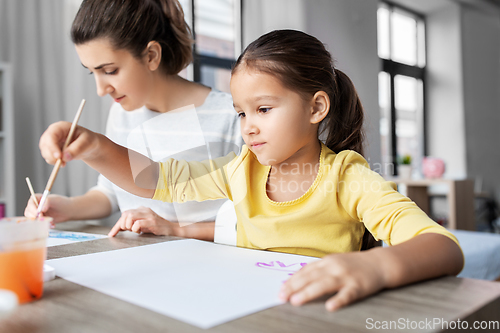 Image of mother with little daughter drawing at home