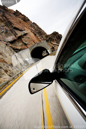 Image of car approacting tunnel through mountains