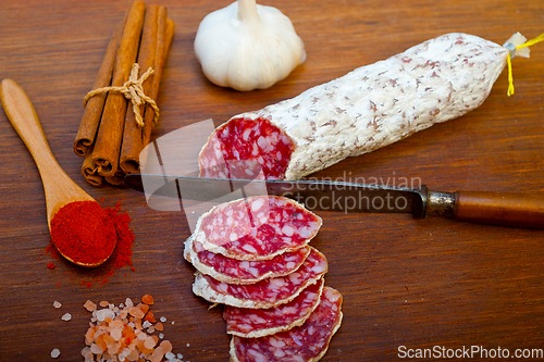 Image of traditional Italian salame cured sausage sliced on a wood board