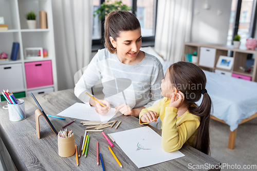 Image of mother with little daughter drawing at home