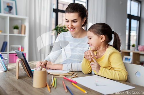 Image of mother and daughter with tablet pc drawing at home