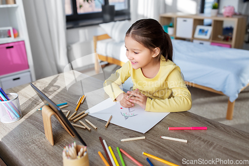 Image of little girl drawing with coloring pencils at home